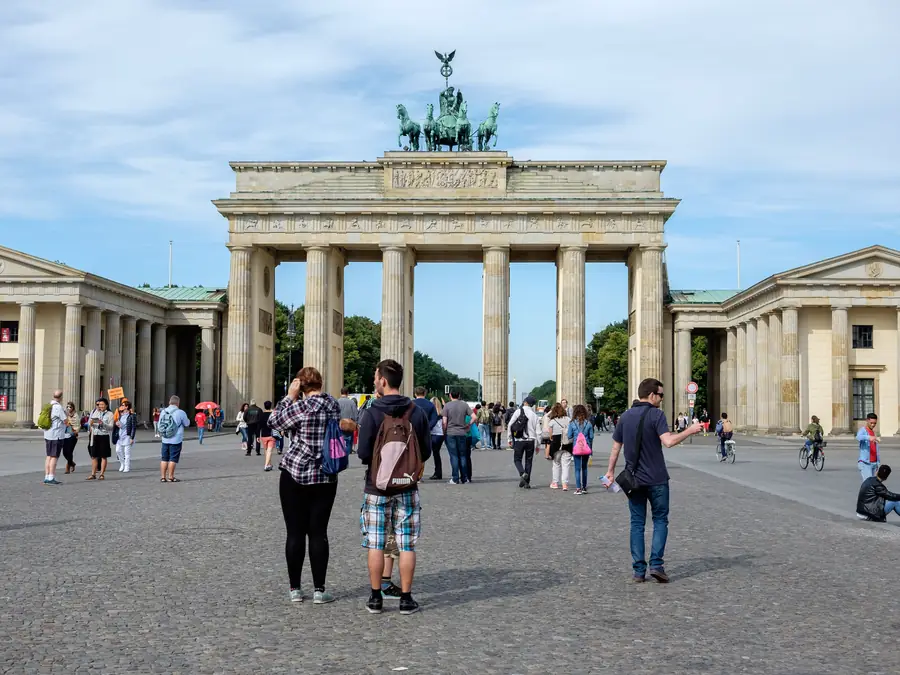 Brandenburger Tor am Pariser Platz mit Reisegruppen bei Tageslicht.