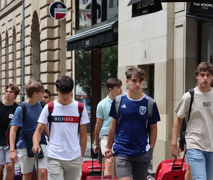 Reisegruppe mit Koffern auf einer Berliner Straße bei der Ankunft.
